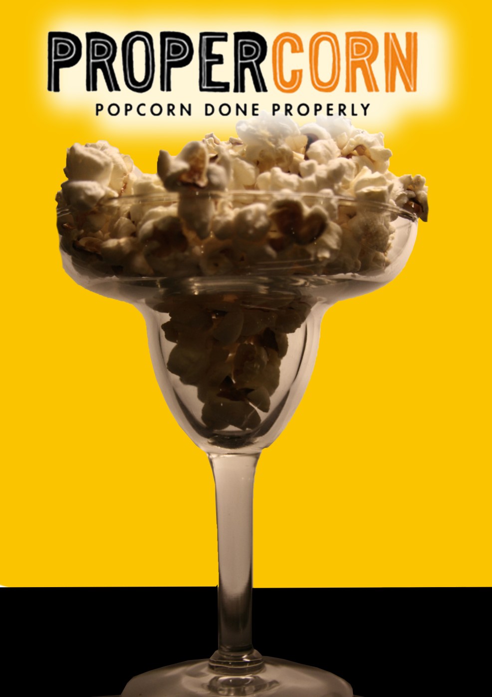 propercorn advertising - popcorn in cocktail glass close up b/w with light orange background